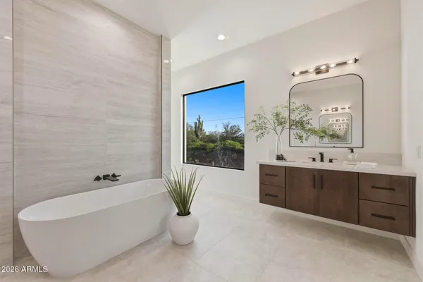 a bathroom with a tub a sink and mirror