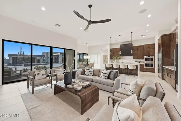 a living room with furniture kitchen view and a large window