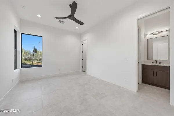 a view of an empty room and chandelier fan
