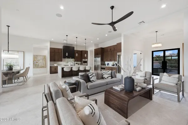 a living room with furniture kitchen view and a large window