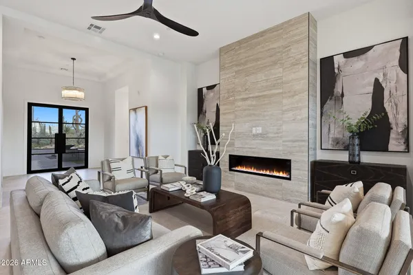 a living room with furniture fireplace and a large window