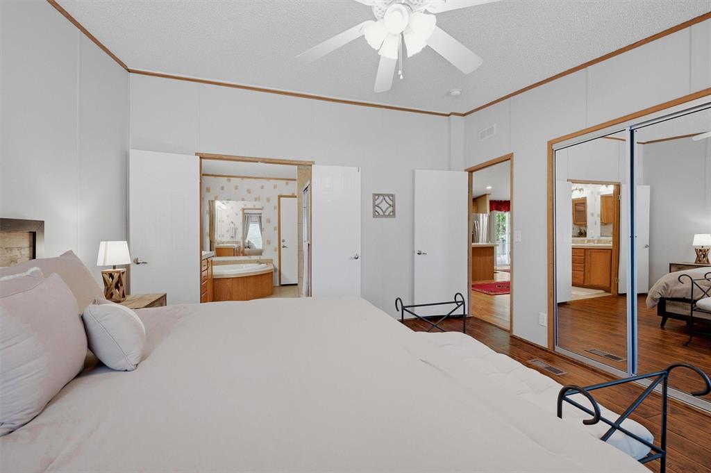 212 Sunset Road Pottsboro, TX 75076 - Photo 12 of 40 a bedroom with a bed and a chandelier