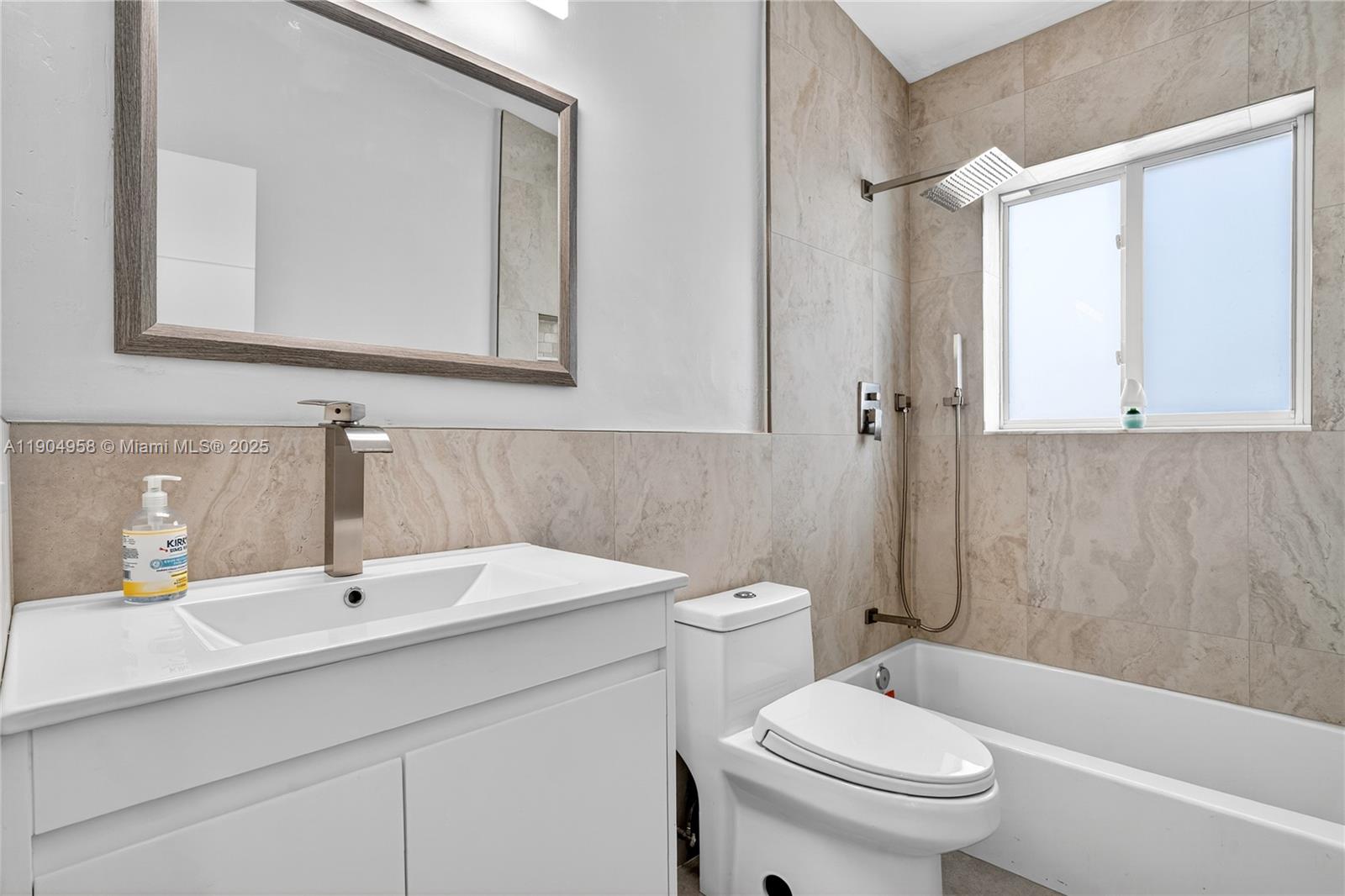 2325 Northeast 194th Street Miami, FL 33180 - Photo 17 of 36 a bathroom with a sink a mirror a toilet and bathtub