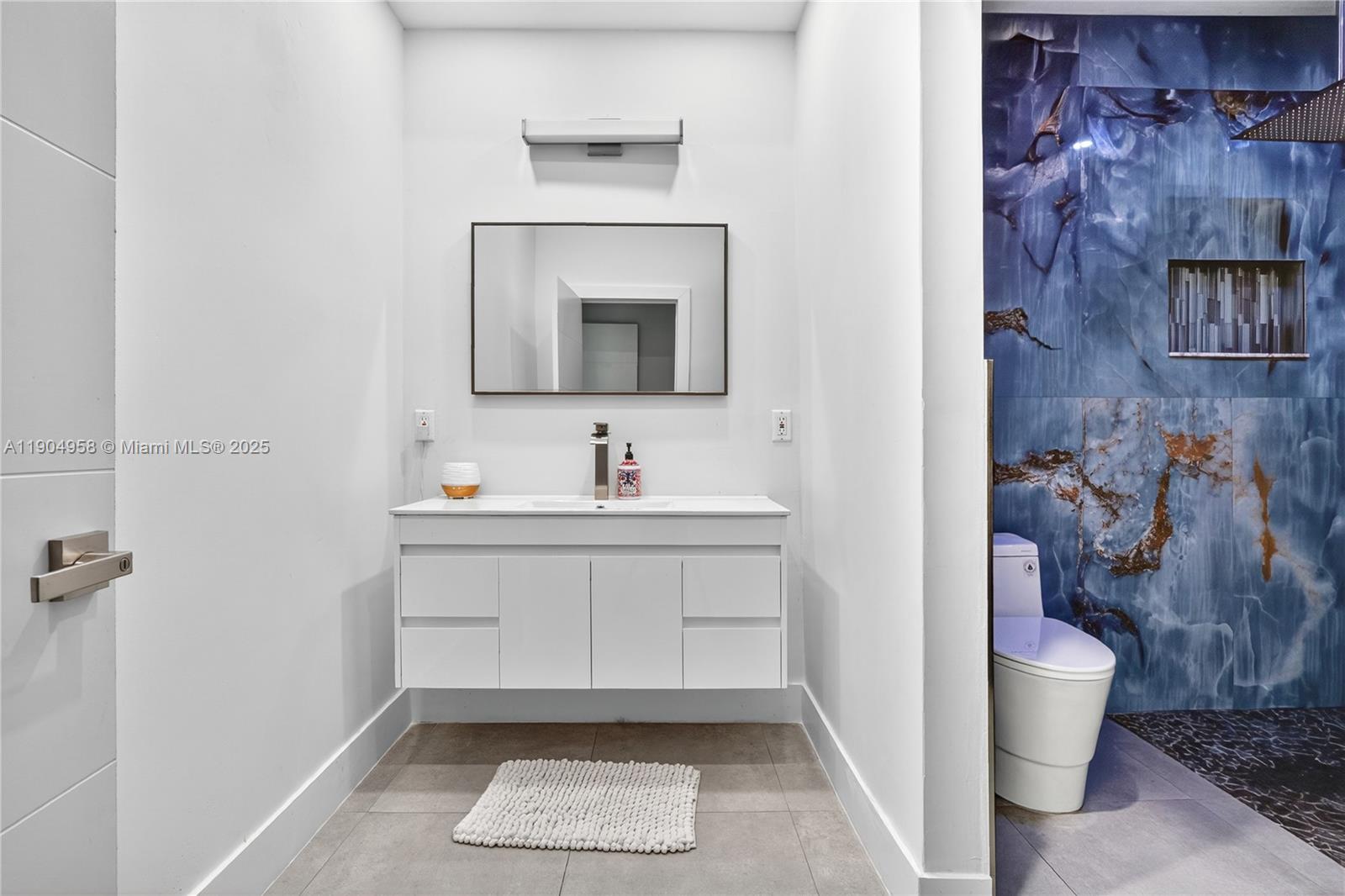 2325 Northeast 194th Street Miami, FL 33180 - Photo 24 of 36 a bathroom with a sink and a mirror