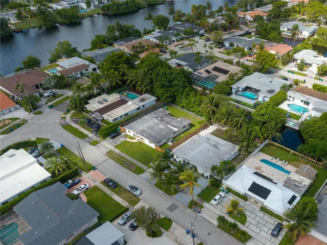 an aerial view of residential houses with outdoor space and lake view