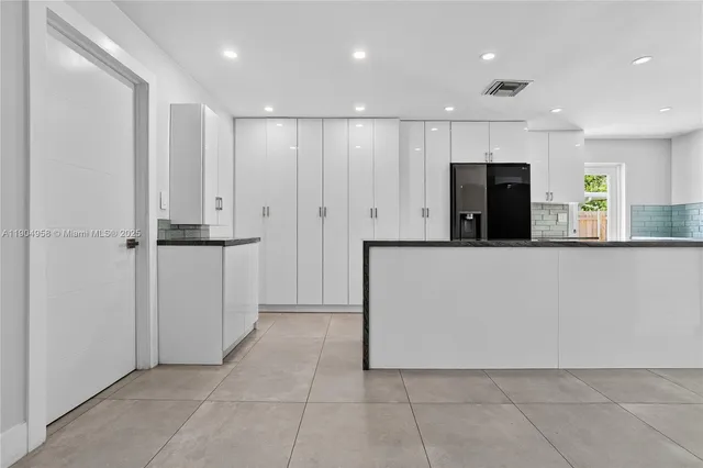 a view of a kitchen with a refrigerator and a sink