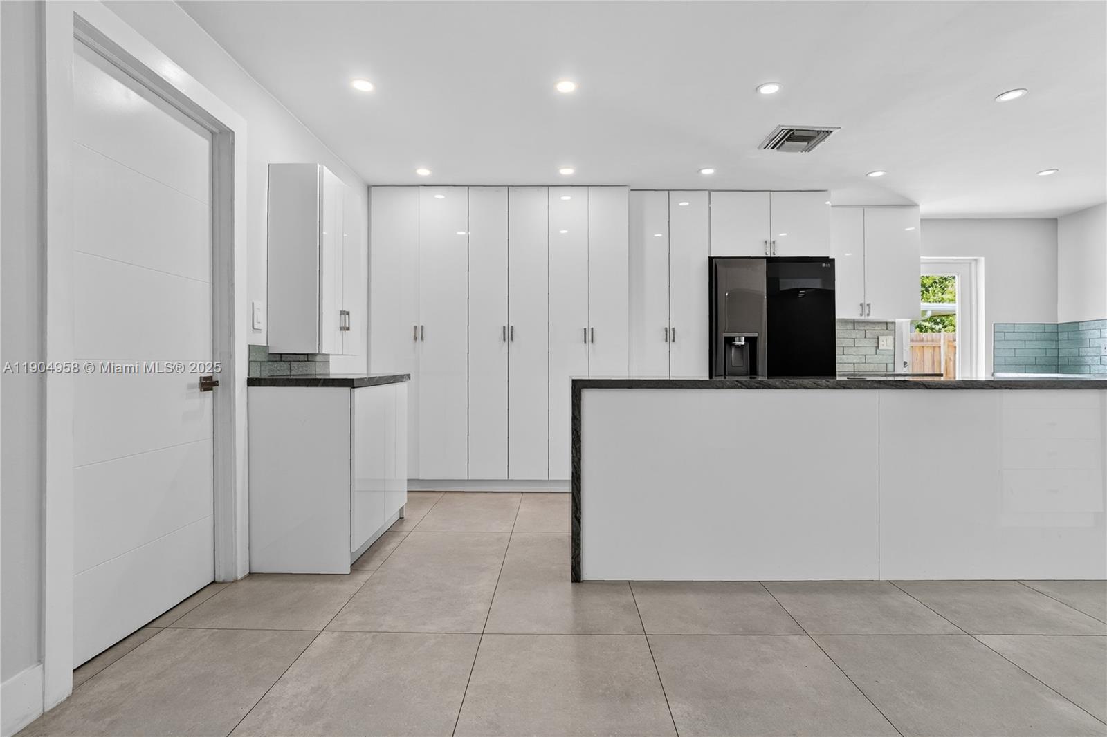 2325 Northeast 194th Street Miami, FL 33180 - Photo 7 of 36 a view of a kitchen with a refrigerator and a sink