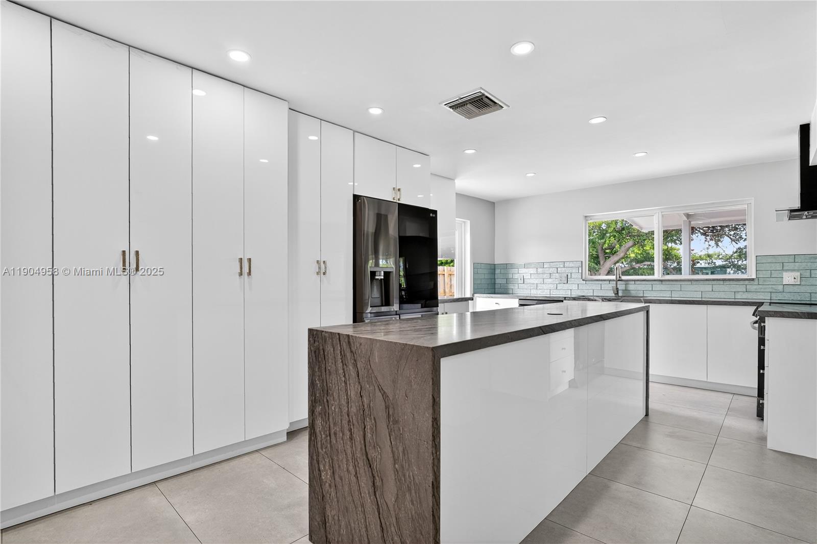 2325 Northeast 194th Street Miami, FL 33180 - Photo 8 of 36 a kitchen with stainless steel appliances granite countertop a sink and cabinets