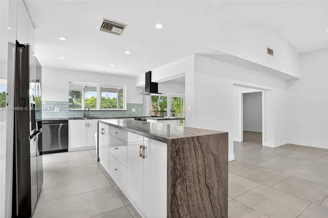 a kitchen with stainless steel appliances granite countertop a sink and cabinets