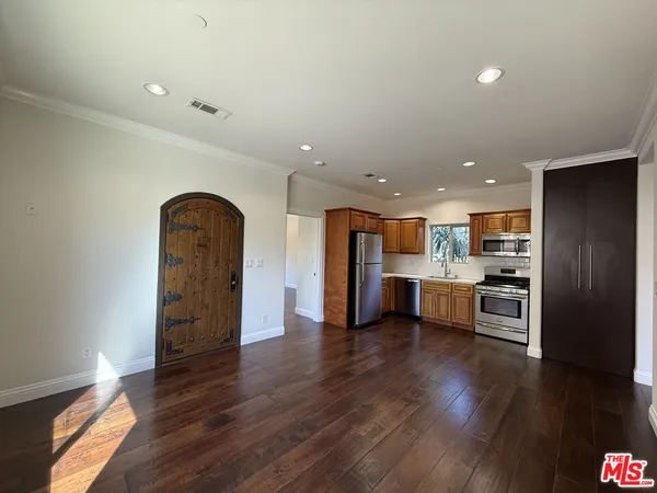 an open kitchen with a refrigerator and a stove top oven