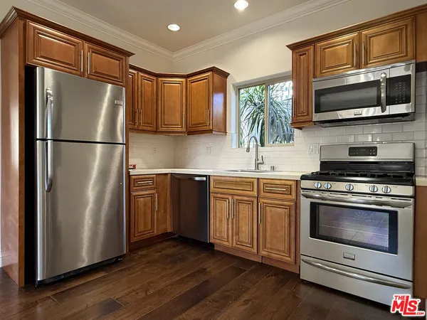 a kitchen with stainless steel appliances a refrigerator stove and microwave