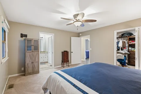 a bedroom with a bed and a flat tv screen on dresser