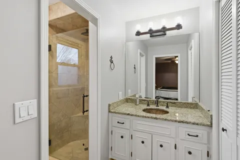 a bathroom with a granite countertop sink toilet and shower