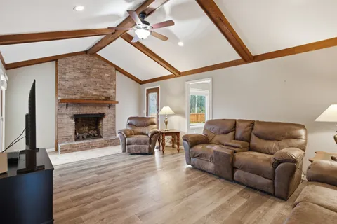 a kitchen with stainless steel appliances granite countertop a sink a stove a refrigerator cabinets and chairs