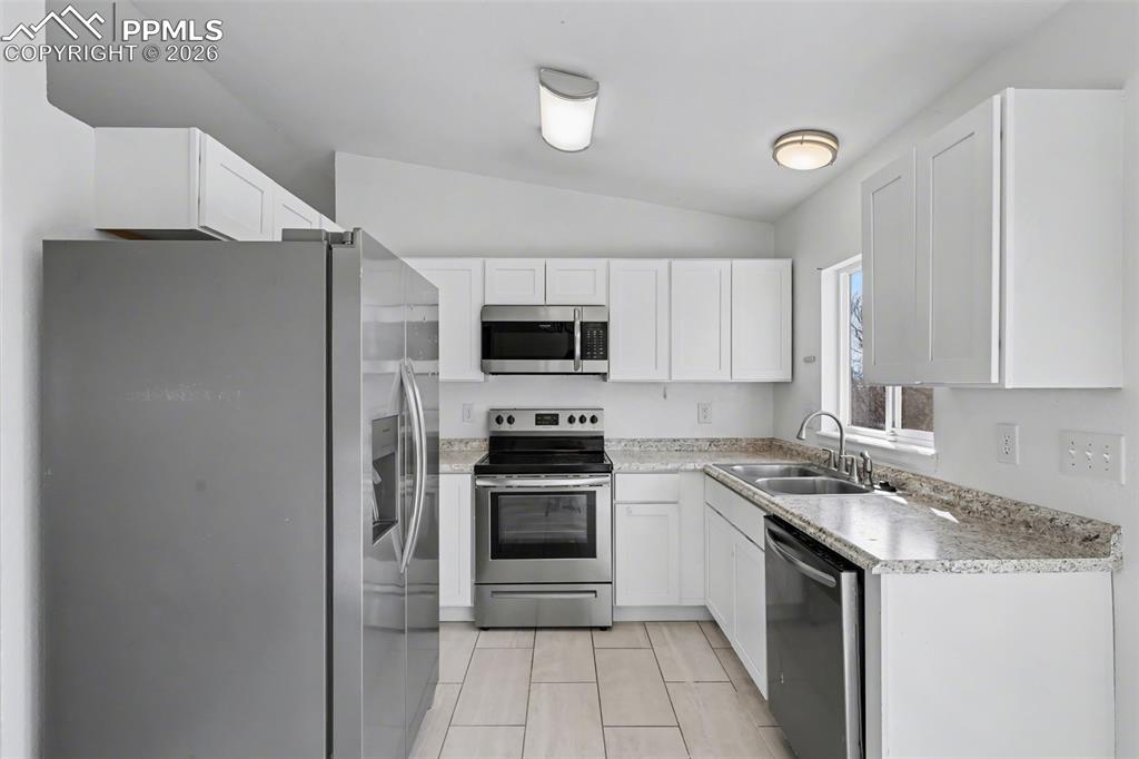 585 Blossom Field Road Fountain, CO 80817 - Photo 11 of 37 a kitchen with stainless steel appliances a stove a microwave and a refrigerator