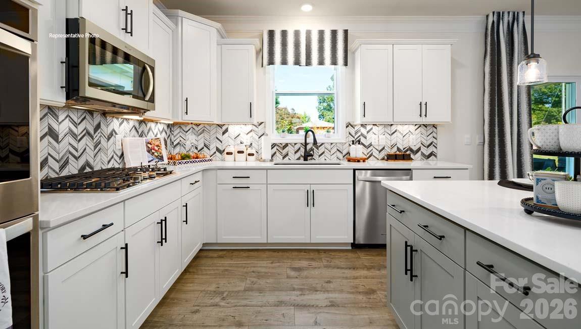 3111 Spring Iris Drive Denver, NC 28037 - Photo 5 of 44 a kitchen with white cabinets sink and stainless steel appliances