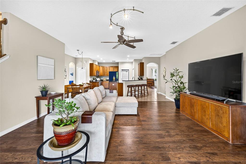 10859 Breaking Rocks Drive Tampa, FL 33647 - Photo 11 of 57 a living room with furniture a flat screen tv and a dining table with wooden floor