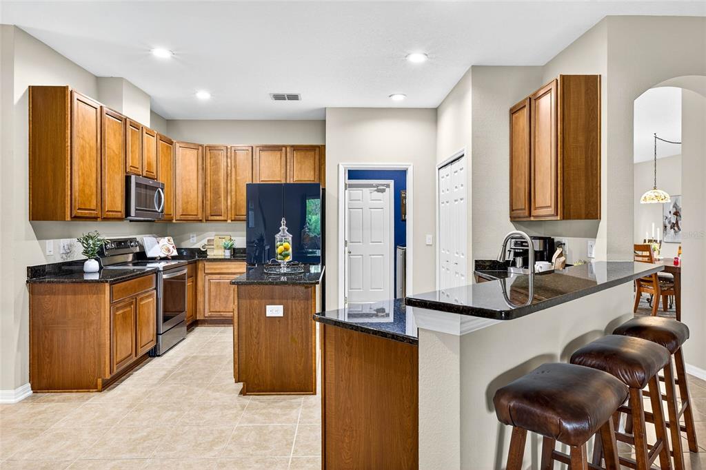 10859 Breaking Rocks Drive Tampa, FL 33647 - Photo 14 of 57 a kitchen with stainless steel appliances granite countertop wooden cabinets a stove top oven a sink and dishwasher