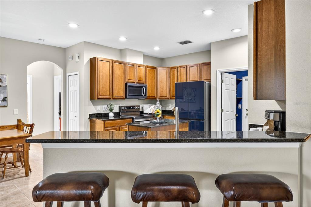 10859 Breaking Rocks Drive Tampa, FL 33647 - Photo 19 of 57 a kitchen with stainless steel appliances granite countertop a table chairs in it and wooden floors