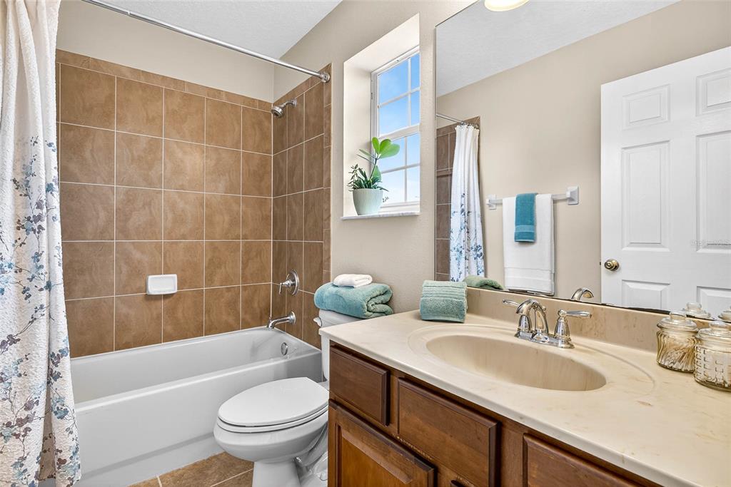 10859 Breaking Rocks Drive Tampa, FL 33647 - Photo 38 of 57 a bathroom with a granite countertop sink a toilet a mirror a bathtub and shower