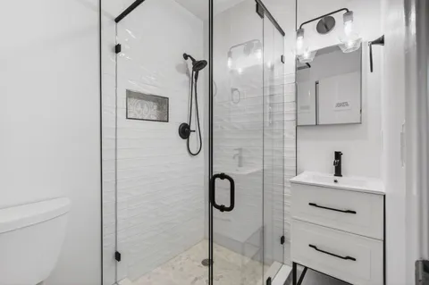 a bathroom with a shower sink and mirror