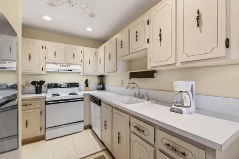 a kitchen with cabinets appliances a sink and a counter top