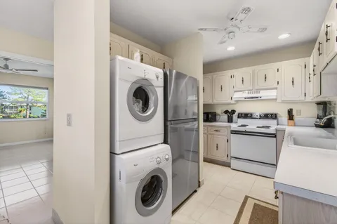a kitchen with cabinets washer and dryer