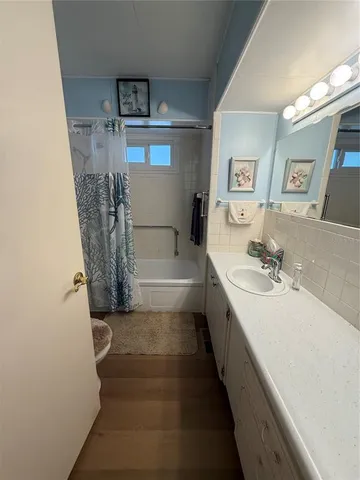 a bathroom with a tub sink and mirror