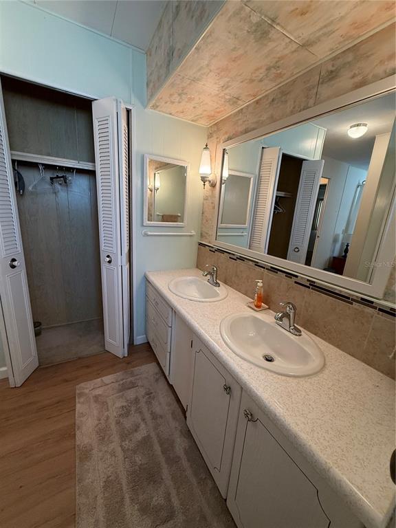 9900 Ulmerton Road, Unit 242 Largo, FL 33771 - Photo 9 of 21 a bathroom with a double vanity sink and mirror