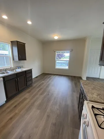 a view of kitchen with granite countertop window and wooden floor
