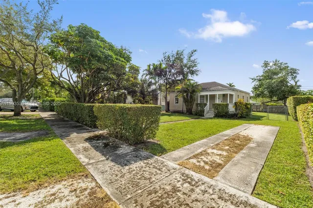 a view of house with garden space and car parked