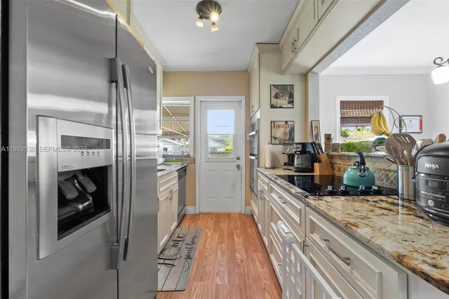 a kitchen with stainless steel appliances granite countertop a stove and cabinets