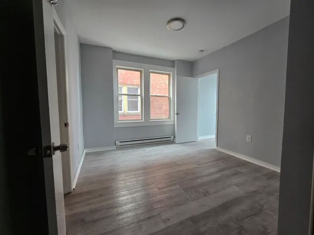 an empty room with wooden floor and a window