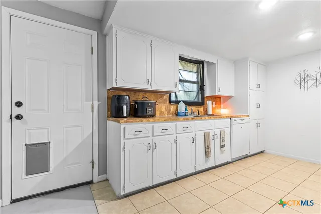 a kitchen with granite countertop white cabinets and white appliances