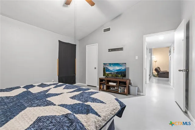 a bedroom with a bed and wooden floor