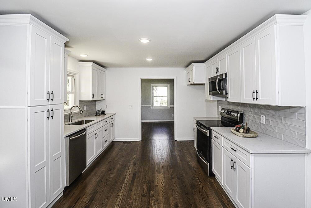 805 River Road Selma, NC 27576 - Photo 12 of 39 a kitchen with stainless steel appliances white cabinets a sink a stove a refrigerator and white cabinets