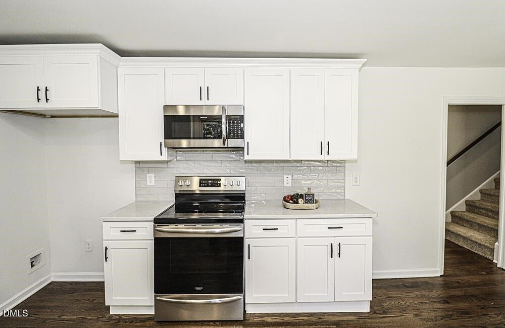 805 River Road Selma, NC 27576 - Photo 14 of 39 a kitchen with stainless steel appliances a stove a microwave and cabinets