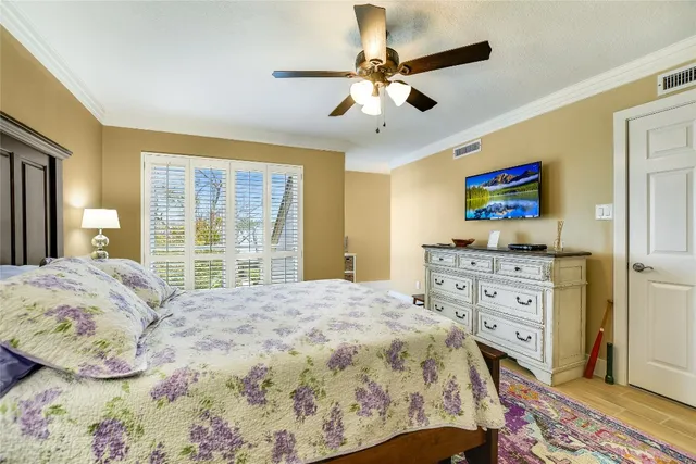 a bedroom with a bed and a flat tv screen on dresser