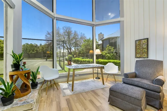 a living room with patio furniture and a potted plant