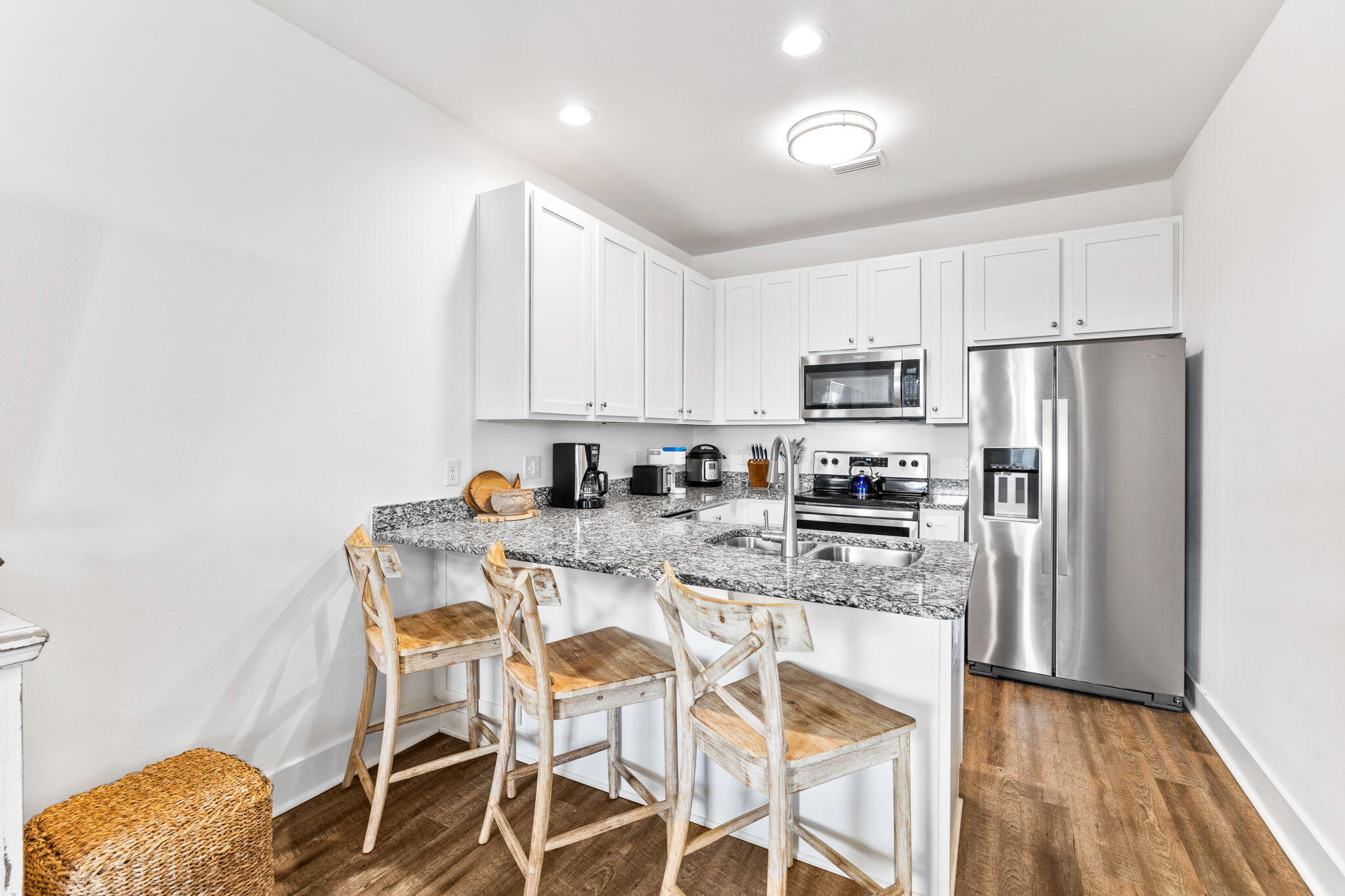 3958 West County Highway 30A, Unit 112 Santa Rosa Beach, FL 32459 - Photo 12 of 45 a kitchen with stainless steel appliances granite countertop a dining table chairs refrigerator and microwave