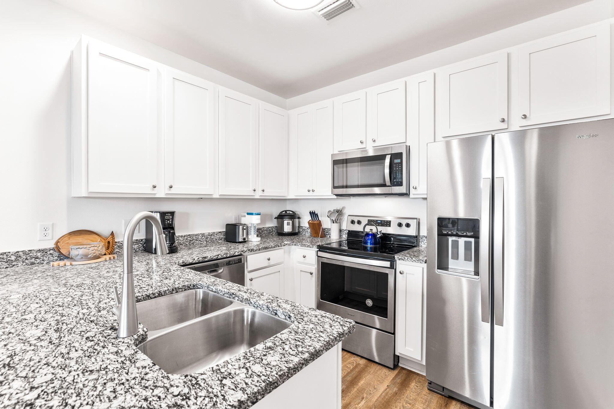 3958 West County Highway 30A, Unit 112 Santa Rosa Beach, FL 32459 - Photo 13 of 45 a kitchen with granite countertop a sink a refrigerator and a stove top oven