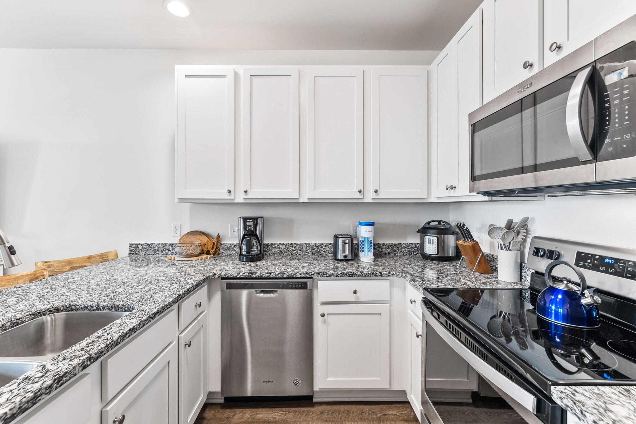 3958 West County Highway 30A, Unit 112 Santa Rosa Beach, FL 32459 - Photo 15 of 45 a kitchen with granite countertop a sink dishwasher stove and cabinets with wooden floor