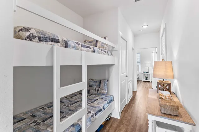 a walk in closet with wooden floor