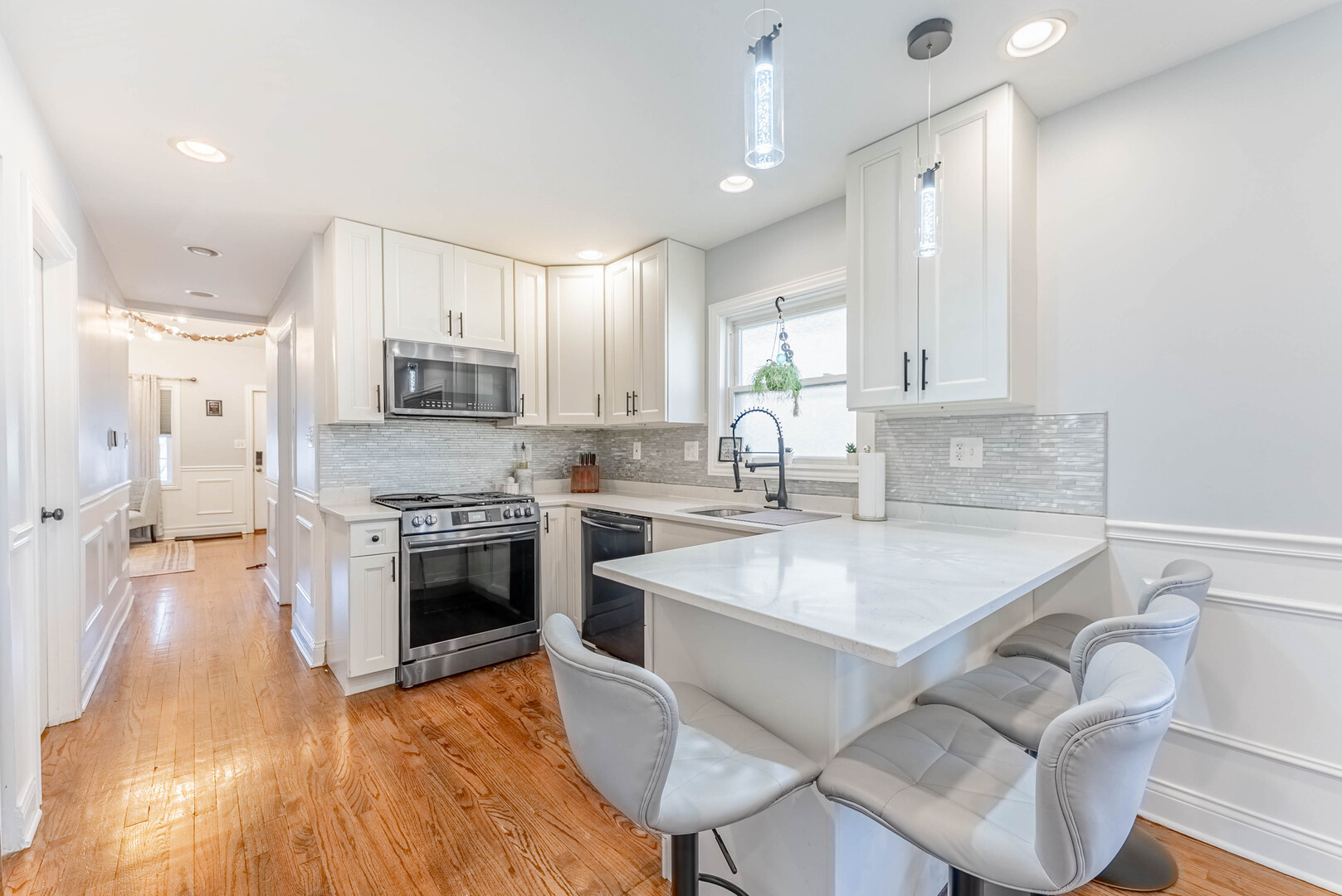 3605 West 56th Place Chicago, IL 60629 - Photo 4 of 23 a kitchen with kitchen island a stove a sink a refrigerator and a dining table with wooden floor