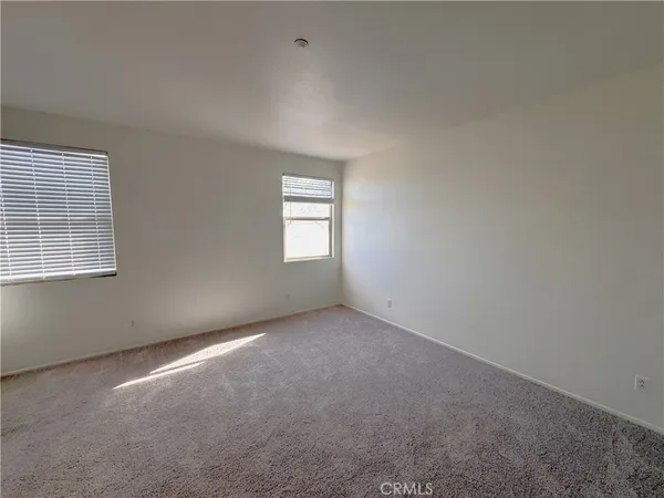 an empty room with a fireplace and windows