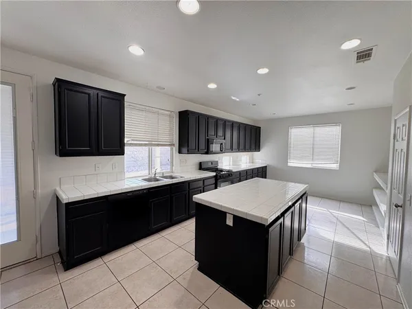 a kitchen with a stove a sink a microwave and cabinets