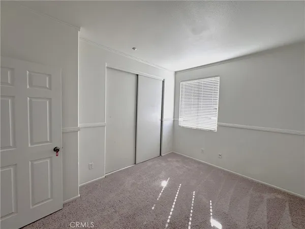 a view of an empty room with closet area