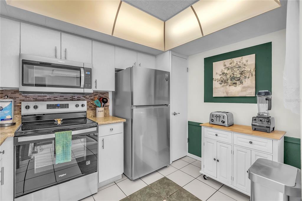 12200 Vonn Road, Unit 2206 Largo, FL 33774 - Photo 9 of 60 a kitchen with white cabinets and stainless steel appliances