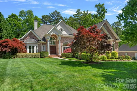 a view of a house with a big yard and potted plants