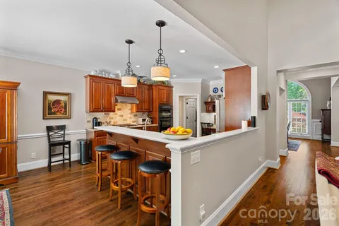 a kitchen that has a lot of cabinets in it and wooden floors